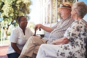 caregiver talking to a senior couple
