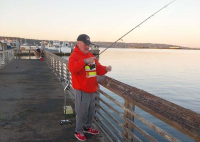 an old man is fishing - Sunrise Services
